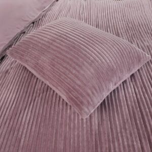 Roze fluwelen geribbelde kussen op bed