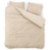 Beige dekbedovertrek met twee kussens op bed