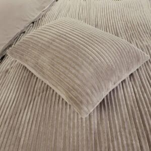 Geribbelde fluwelen kussen op een bed