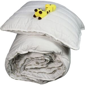 Wit kussen en dekbed met geel speelgoed in giraffevorm.