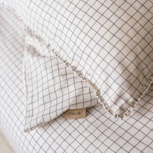 Geruit kussensloop op bed biedt comfort en stijl.