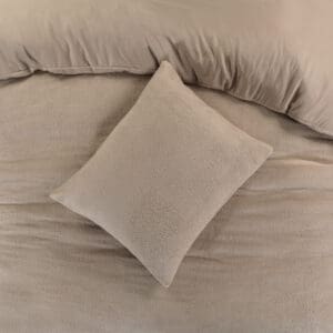 Beige kussen op bed met dekbed