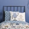 Kinderbeddengoed met robotprint op een metalen bed.