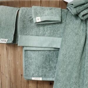 Groene handdoeken op houten badkuip