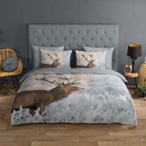 Dekbedovertrek met hertenprint en planten in slaapkamer.