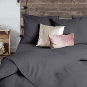 Grijs dekbedovertrek met sierkussens op bed