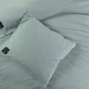 Groene kussensloop op bed met label