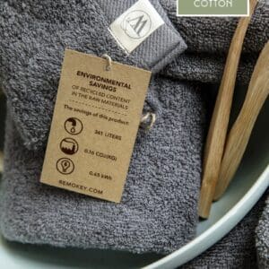 Grijze handdoek van gerecycled katoen met milieubewuste label.