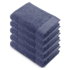 Gestapelde blauwe handdoeken op een witte achtergrond.