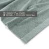 Groene handdoek met wasinstructies op label.