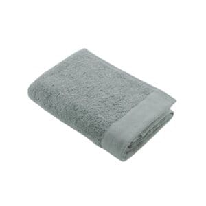 Groene badhanddoek opgevouwen op witte achtergrond.