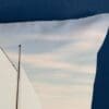 Kussen met zeilboot motief op blauwe achtergrond.