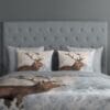 Luxe dekbedovertrek met edelhertontwerp op bed.